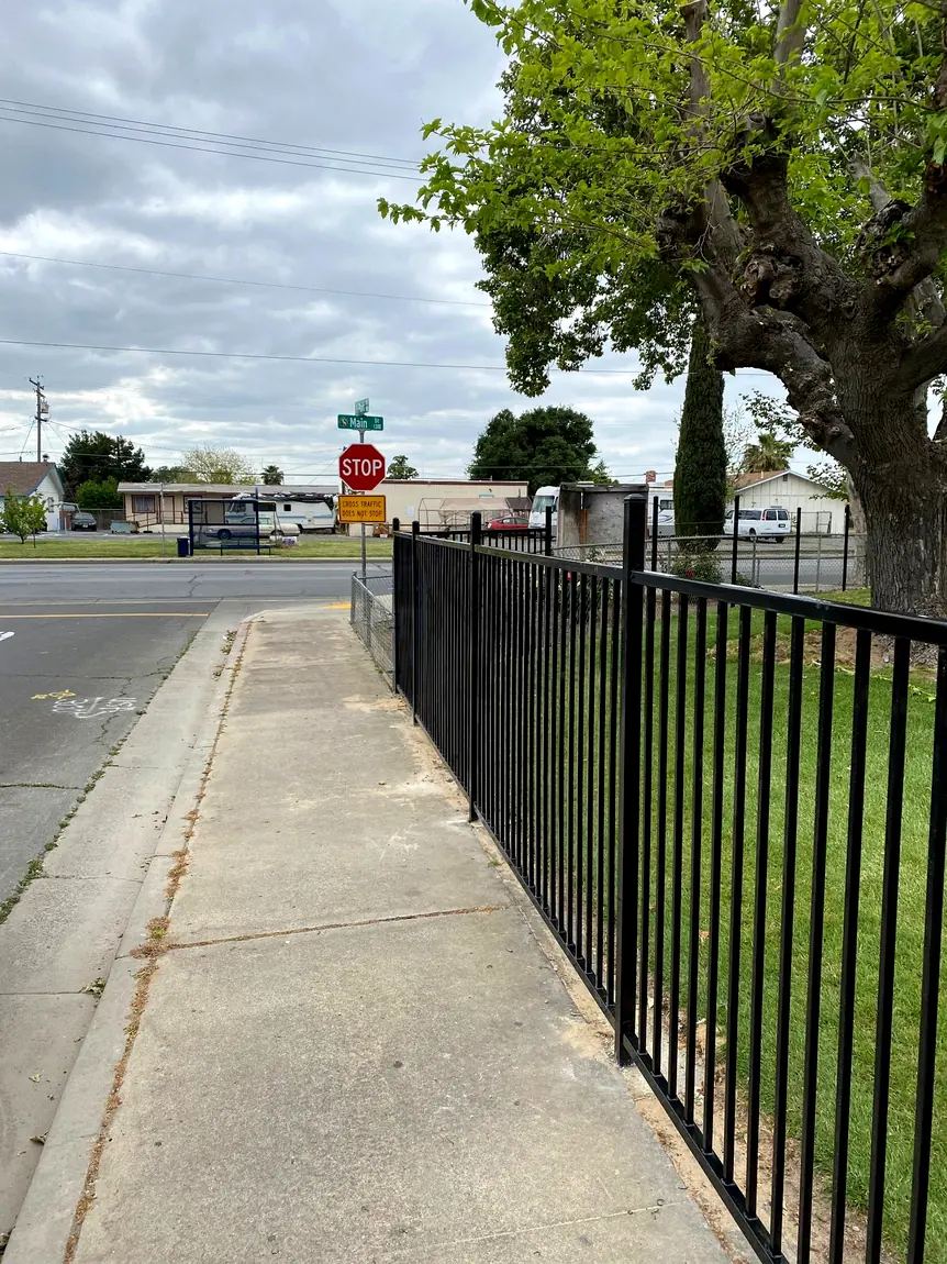 Black ornamental fence along sidewalk