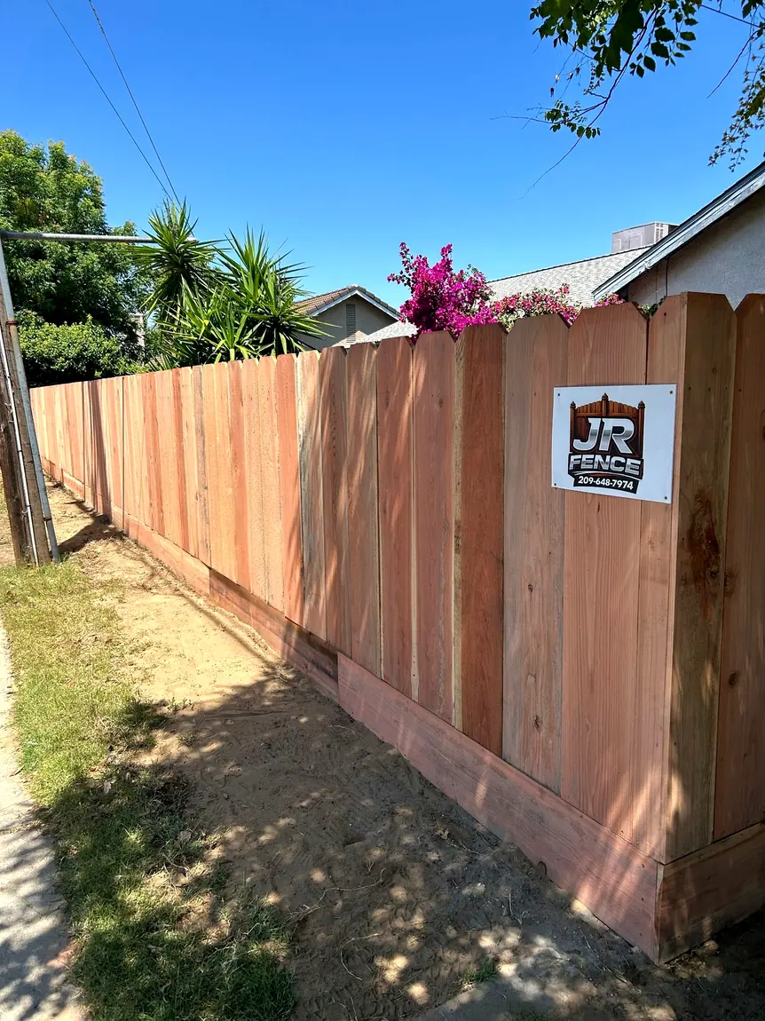Wood fence with JR Fence sign