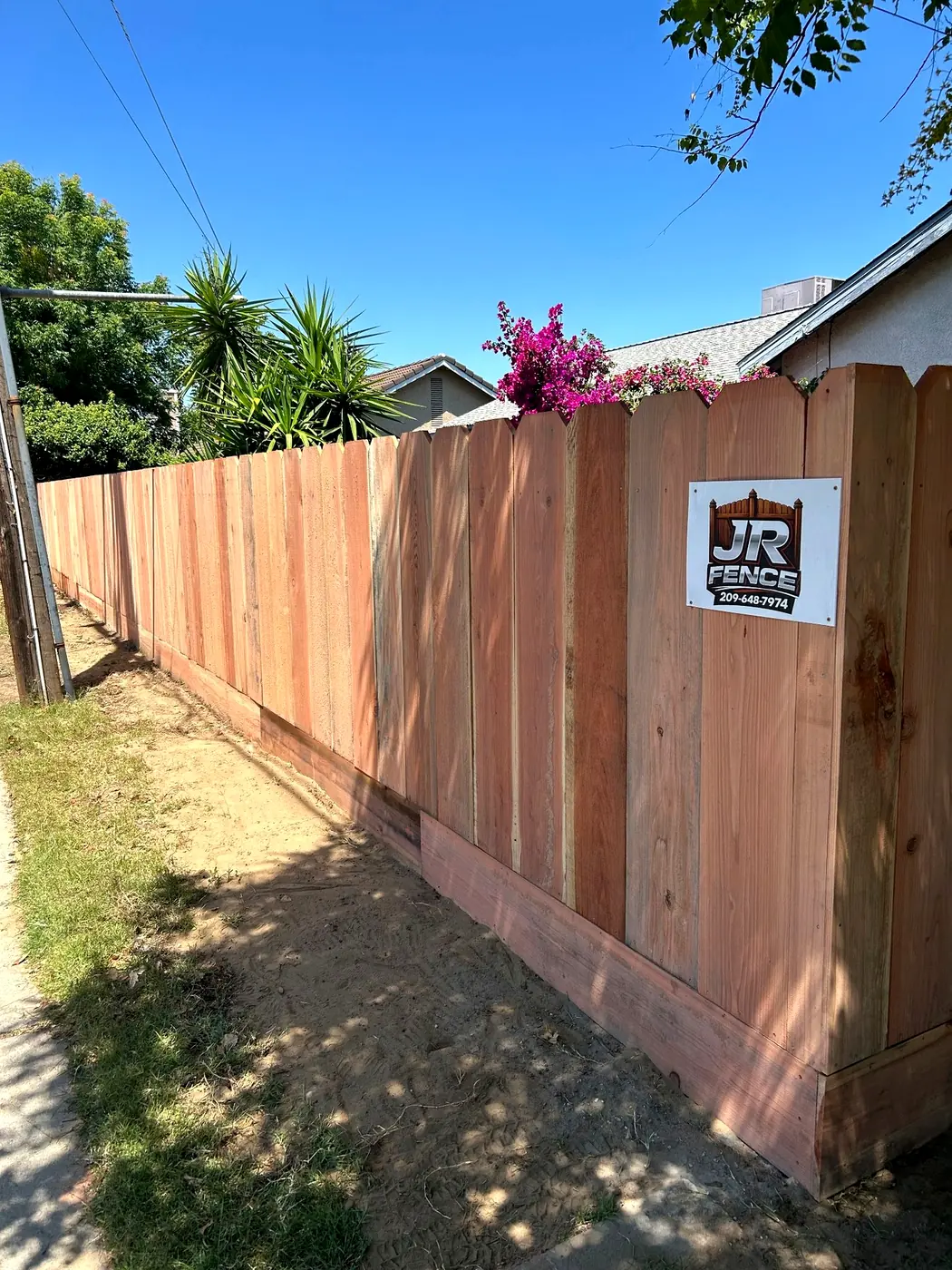 Wood fence with JR Fence sign